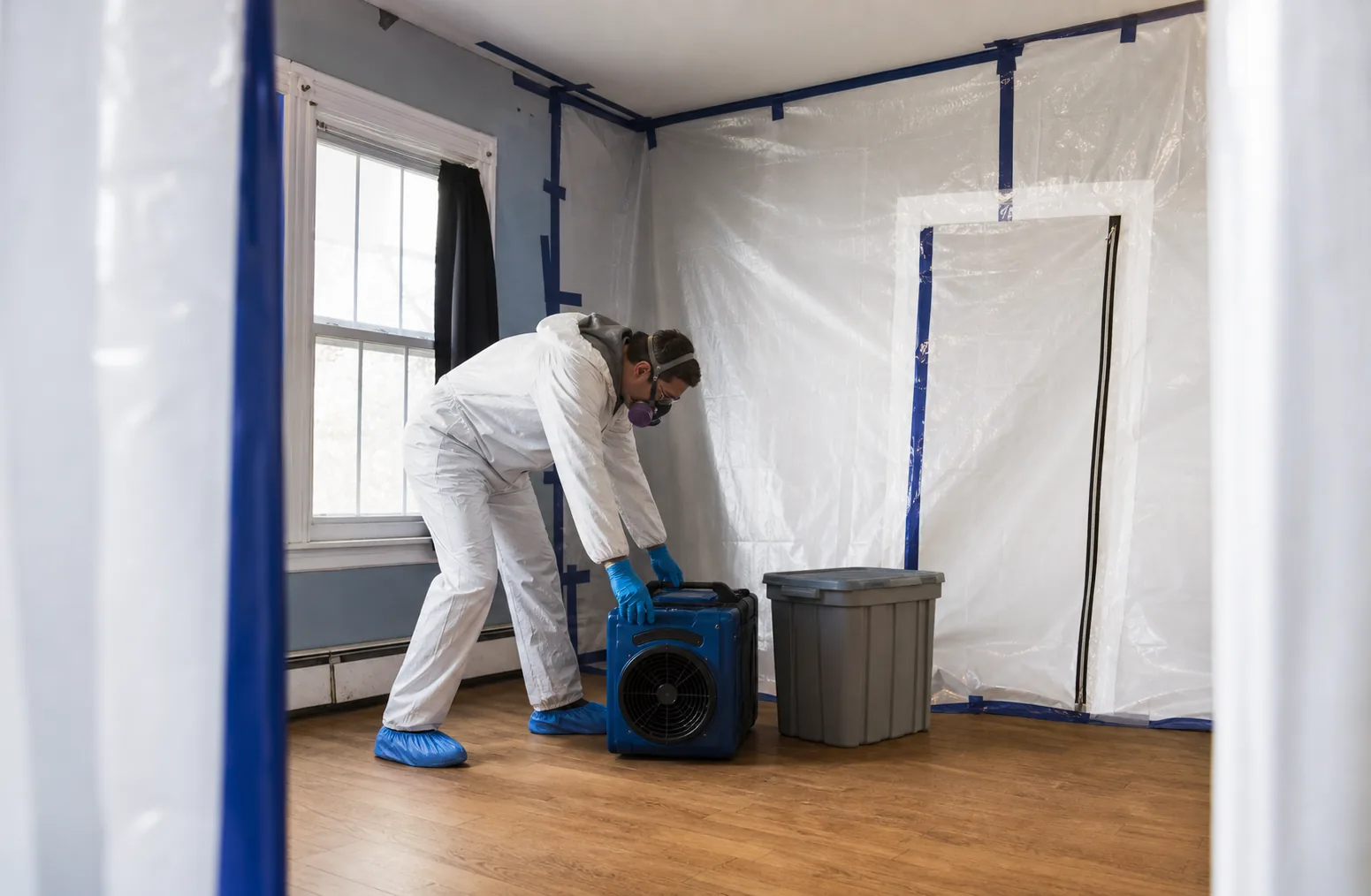 Illustrative technician positioning air-control equipment inside a contained empty room